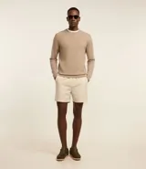 Suéter de punto color borgoña, con cuello redondo, sisas ligeramente desplazadas y bajo y puños acanalados.