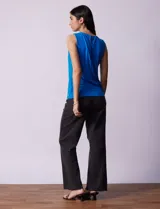 Musculosa negra de poliéster y elastano, con cuello redondo con frunces delanteros y abertura con botón en la espalda.