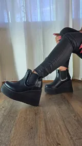 Botas cortas de cuero color suelo y negro con detalles en animal print de leopardo, con plataforma y taco cuña tricolor en negro, blanco y suela. Incorpora elásticos laterales estilo chelsea.