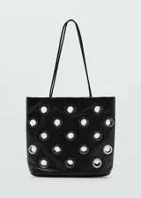 Bolso tipo shopper de color negro con diseño de ojales metálicos plateados. Cuenta con doble asa de hombro y cierre de botón magnético.