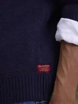 Sweater de cuello redondo confeccionado en mezcla de lana, con diseño de tejido de punto y sutiles líneas verticales en contraste.