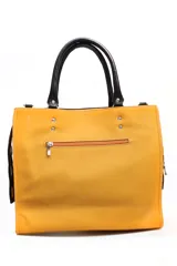 Cartera de cuero color amarillo con textura granulada, asas superiores en color negro y detalles de remaches metálicos. Incluye el logo de la marca grabado en el frente.