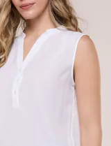 Blusa de gasa sin mangas de calce holgado, marca Sioni. Cuenta con cuello cadete, abertura frontal en V con media cartera de botones, espalda con canesú y pliegue central, y ruedo redondeado.