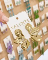 Aros de diseño orgánico con acabado metálico brillante en tono dorado, con forma de flor o pétalos irregulares.