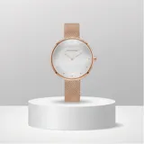 Reloj analógico de mujer con caja redonda de metal color oro rosa y malla de acero tipo milanesa. Presenta una esfera minimalista con índices simples y movimiento de cuarzo japonés.