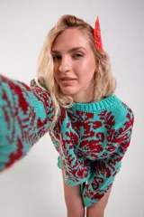 Sweater de punto con diseño estampado en color turquesa y bordó, de corte holgado, con cuello redondo y mangas largas.