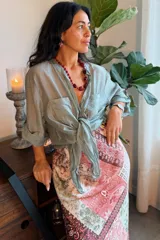 Camisa de seda blanca de corte holgado, con mangas tres cuartos con trabilla para arremangarlas, cuello camisero, cierre frontal con botones y dos bolsillos en el pecho.