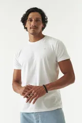 Remera básica de algodón color blanco, con escote redondo, mangas cortas y detalle de logo bordado en el pecho.