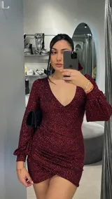 Minivestido de fiesta color bordó con brillos, escote en V y mangas largas abullonadas.