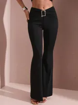 Pantalón negro de corte acampanado, con cintura alta y detalle de hebilla rectangular con pedrería en el frente.