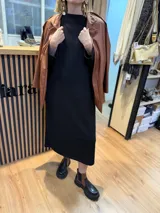 Vestido midi color beige de tejido acanalado, con cuello alto y mangas largas.