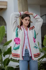 Cárdigan largo de punto color crudo con bordados florales multicolores hechos a mano.