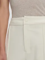 Pantalón de vestir color beige, de corte recto, con pinzas delanteras y cintura elástica lateral.