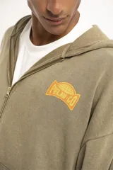 Campera con capucha color verde oliva, con cierre frontal y bolsillos laterales. Estampado con logo en el pecho.
