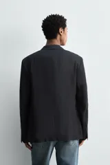 Blazer de corte relajado confeccionado en lino italiano, con cuello de solapas de muesca, cierre frontal de un botón, bolsillo de vivo en el pecho y bolsillos de plastrón en la cadera.