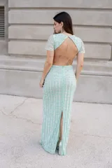 Vestido largo de micro tul color verde agua, bordado con piedras y lentejuelas en patrón geométrico. Cuenta con escote en V, mangas cortas fluidas y silueta ajustada.