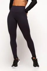 Calza deportiva de compresión color negro, de tiro alto y diseño ajustado.