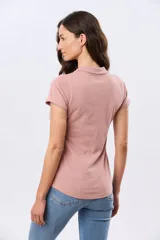 Remera polo de algodón color beige con mangas cortas, escote en V y cuello camisero. Presenta delicados mini bordados florales distribuidos en toda la prenda.