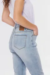 Pantalón de jean skinny de tiro medio, color celeste claro, con efecto desgastado y costuras en contraste.