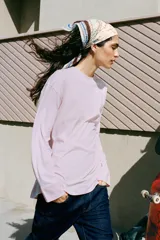 Camiseta oversize de manga larga color rosado, con cuello redondo y bajo recto.