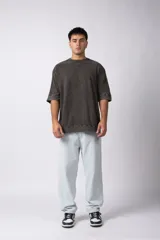 Remera de corte oversize con efecto de lavado gastado, confeccionada en algodón pesado. Presenta cuello redondo, mangas cortas con costuras visibles y un diseño amplio.