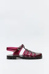Sandalias tipo jelly color borgoña, con diseño entrecruzado, hebilla lateral ajustable y suela con relieve.