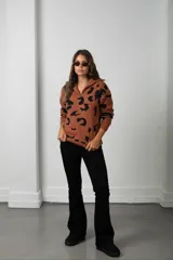 Buzo de tejido de punto con estampado animal print, cuello alto con cierre frontal y mangas largas.