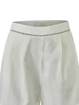 Short de tiro medio confeccionado en mezcla de lino orgánico y viscosa, color beige. Presenta diseño con pinzas frontales, bolsillos laterales y detalles de calados decorativos en la cintura y en el ruedo.