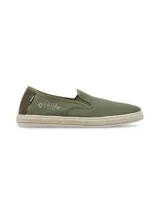 Alpargatas slip on RKF modelo Camaeli, color verde militar, confeccionadas con materiales reciclados. Presentan diseño de punta redonda, detalles elásticos en los laterales para un calce fácil, suela revestida en yute trenzado y un sutil bordado lateral de espina de pescado.