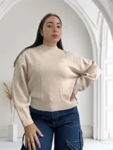 Sweater beige de tejido de punto con cuello redondo y mangas largas.