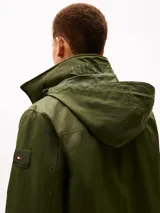 Campera Tommy Hilfiger de color verde militar, con cuello alto, cierre frontal de cremallera y bolsillos laterales. Confeccionada en poliamida, presenta un diseño clásico y versátil con el logo de la marca bordado discretamente en el pecho.