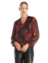 Blusa de gasa con estampado floral en tonos rojos sobre fondo negro. Presenta escote en V, mangas largas traslúcidas con puños ajustados y detalles de fruncido en los hombros.