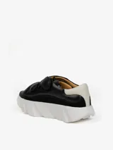 Zapatillas negras de cuero con plataforma blanca y talonera blanca en contraste. Presentan cuatro correas de velcro y suela con dientes de gran formato.
