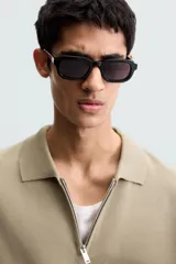 Polo de punto color verde oliva, de manga corta y corte relajado. Presenta cuello solapa con cierre frontal de cremallera.