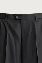 Pantalón de traje regular fit negro, confeccionado en lana italiana, con bolsillos laterales, bolsillos traseros de vivo con botón y cierre frontal de cremallera y botón.