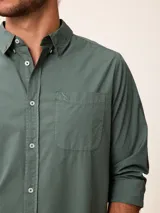 Camisa de manga larga en color azul, confeccionada en algodón con técnica de teñido garment dye. Presenta cuello abotonado, cierre frontal con botones y un bolsillo en el pecho con detalle bordado.