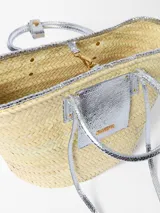 Bolso canasto Jacquemus Le Panier Soli tejido en fibra vegetal con detalles en cuero metalizado plateado, dos asas cortas de mano y bolsillo frontal con logotipo en letras doradas.
