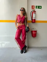 Pantalón rojo de cuero sintético con flecos largos en los laterales.