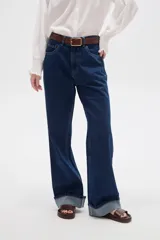 Pantalón de jean azul oscuro, de corte recto y tiro alto, con botamanga rebatida.