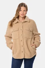 Campera tipo camisa confeccionada en tejido de sherpa, con cuello clásico, cierre frontal de botones y bolsillos delanteros con solapa.