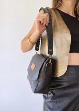 Cartera bandolera negra de cuero con textura tipo cocodrilo y correa trenzada.