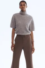 Pantalón de corte bootcut con estampado de pata de gallo en tonos marrones. Presenta cierre frontal con pretina prolongada, botón oculto y corchetes, además de raya marcada en la parte delantera y trasera, bolsillos laterales al bies y bolsillos traseros ribeteados.