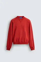 Sudadera de cuello redondo con efecto lavado, confeccionada en tejido de algodón con interior de rizo. Presenta manga larga raglán y acabados en rib en puños y cintura.