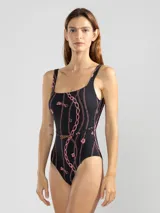 Malla entera negra con estampado de cadenas y flores rosadas. Incluye cinturón fino con hebilla dorada.