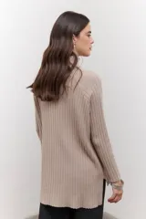 Polera de tejido de punto acanalado en color negro, con cuello alto y diseño de corte recto con largo asimétrico, más corto adelante y más largo atrás.