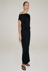 Vestido midi negro confeccionado en hilatura de viscosa, de diseño satinado y corte asimétrico con escote fluido y manga sisa. Presenta bajo acabado en línea evasé y cierre lateral con cremallera oculta en costura.