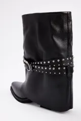 Bota de caña media confeccionada en cuero vacuno negro, con diseño de estilo western. Presenta una puntera estilizada, taco bajo y una correa decorativa con tachas metálicas y hebilla plateada que rodea el tobillo.