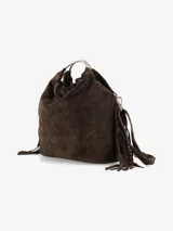 Cartera de mano confeccionada en cuero gamuzado color marrón, con diseño flexible y detalles de flecos laterales. Presenta un asa rígida metálica circular y una abertura superior fruncida.
