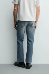 Jeans regular fit de denim de algodón en color gris con efecto lavado, tiro medio, diseño de cinco bolsillos y cierre frontal con botones.