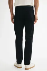 Pantalón slim fit negro de sarga de algodón, de corte ajustado, con cinco bolsillos y cierre frontal con botón y cremallera.